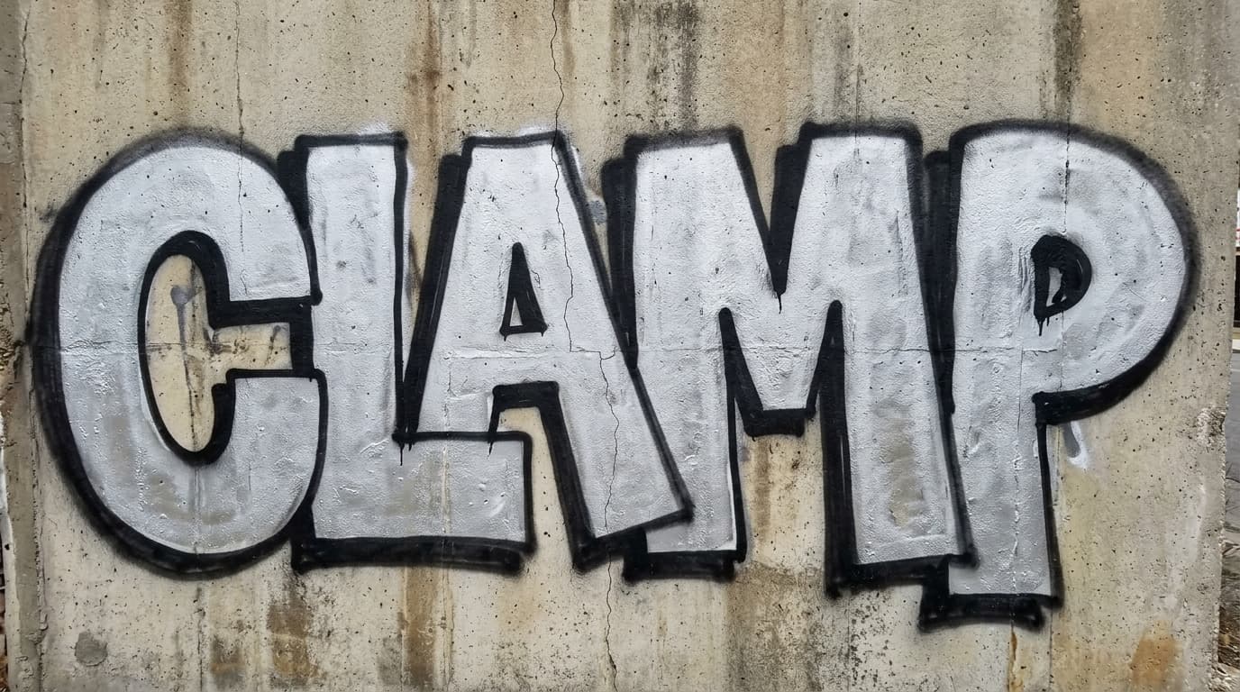 Failed straight-letter graffiti word CLAMP on concrete with cramped L-A spacing, heavy M-P join, and choked P counter